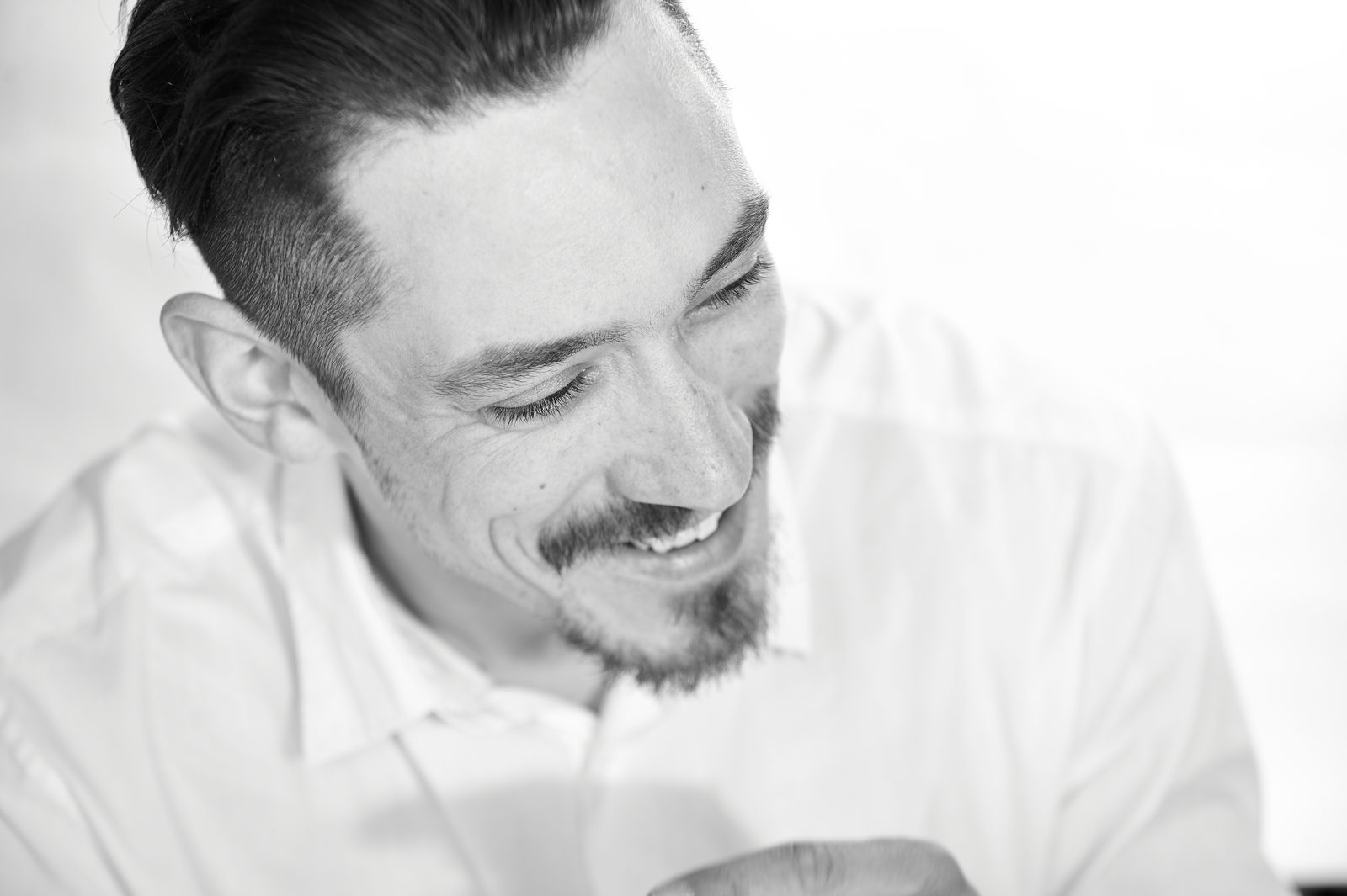 Lachender Mann im weißen Hemd, Schwarzweiß-Portrait